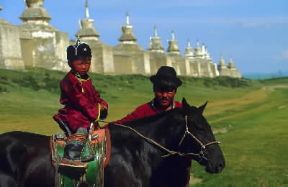 Mongolia. Bambino a cavallo e, sullo sfondo, il monastero di Erdeni-zu. De Agostini Picture Library / W. Buss Mongolia. Bambino a cavallo e, sullo sfondo, il monastero di Erdeni-zu. De Agostini Picture Library / W. Buss