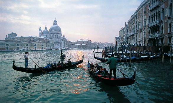 Venezia, Canal grande L’immagine ci propone un suggestivo scorcio del Canal Grande con una veduta della chiesa della Salute in una tipica giornata invernale: il cielo plumbeo appare chiuso e immobile, l’acqua della laguna si tinge di un verde oliva, denso e cupo, la neve imbianca i tetti dei palazzi e fa assumere alla città un volto completamente nuovo. Venezia, Canal grande L’immagine ci propone un suggestivo scorcio del Canal Grande con una veduta della chiesa della Salute in una tipica giornata invernale: il cielo plumbeo appare chiuso e immobile, l’acqua della laguna si tinge di un verde oliva, denso e cupo, la neve imbianca i tetti dei palazzi e fa assumere alla città un volto completamente nuovo.